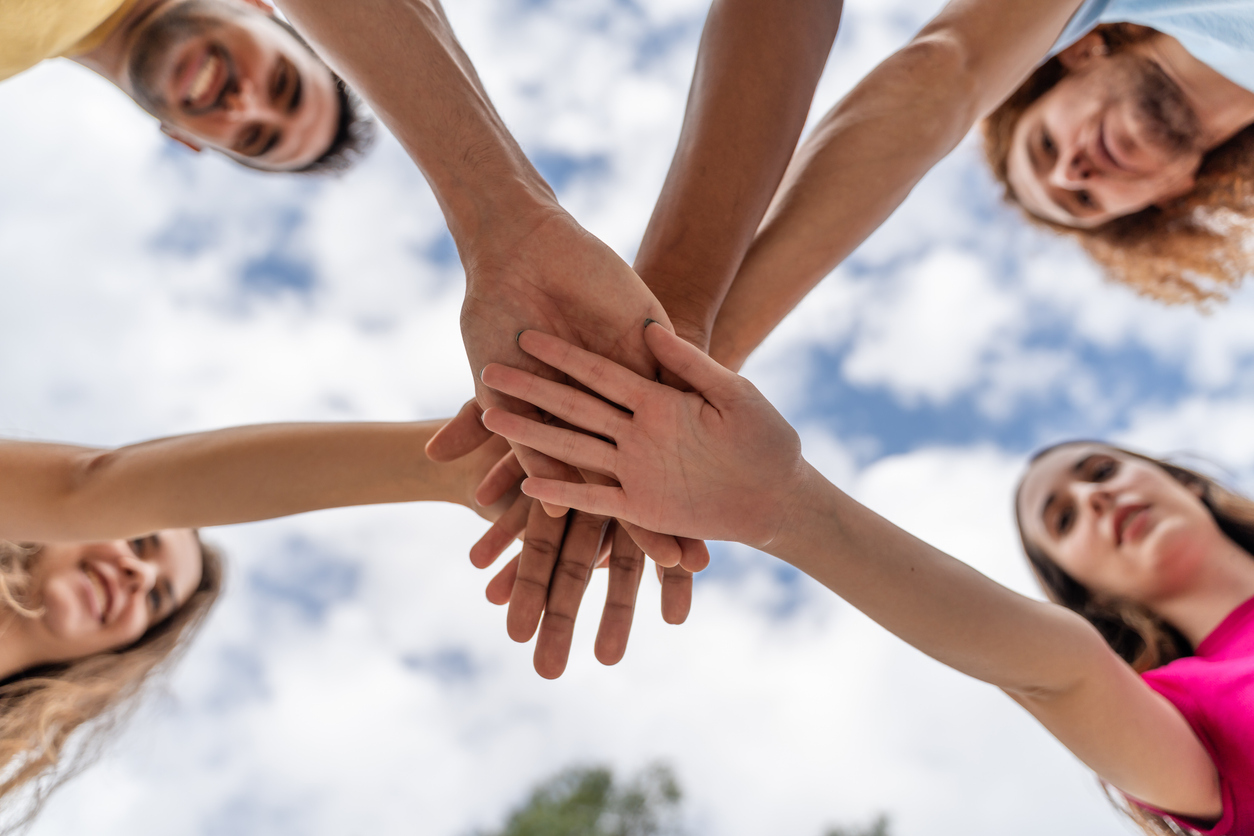 Low angle view of a group of young people stacking their hands together